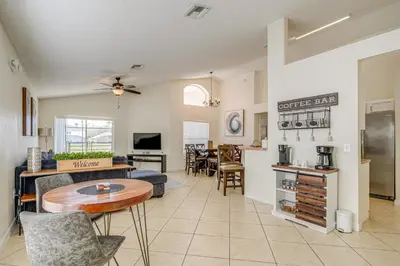 a living room with a table and a kitchen at 9 Mi to Disney Home with Pool Table and Water Views! in Kissimmee