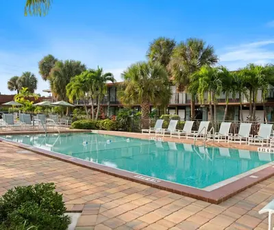 a large swimming pool with chairs and palm trees at Magic Tree Resort by Coolvacay in Orlando