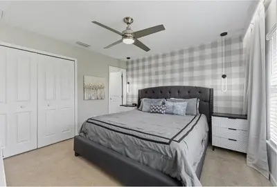 a bedroom with a bed and a ceiling fan at Beautiful 4BD home Themed Pool and Grill 4403 in Kissimmee