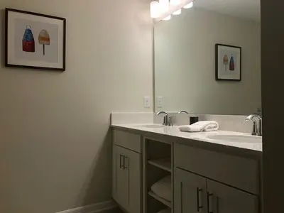 a bathroom with a sink and a large mirror at Aqua Vista Gated Resort Style Community Storey Lake in Kissimmee