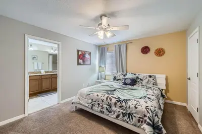 a bedroom with a bed and a ceiling fan at Luxury 5BR Townhome w Pool & Resort Access in Kissimmee