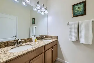 a bathroom with two sinks and a large mirror at Luxury 5BR Townhome w Pool & Resort Access in Kissimmee