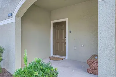 a front door of a house with a bench at Luxury 5BR Townhome w Pool & Resort Access in Kissimmee
