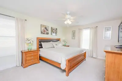 a bedroom with a bed and a ceiling fan at Spacious 6BR Villa Sleeps 14 in Kissimmee