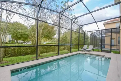 a swimming pool in a building with a large window at Spacious 6BR Villa Sleeps 14 in Kissimmee