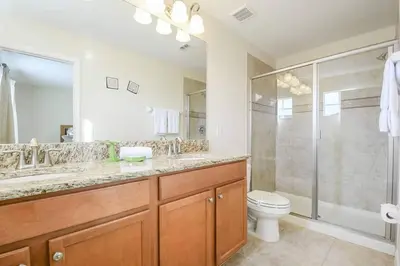 a bathroom with a shower and a toilet and a sink at Spacious 6BR Villa Sleeps 14 in Kissimmee