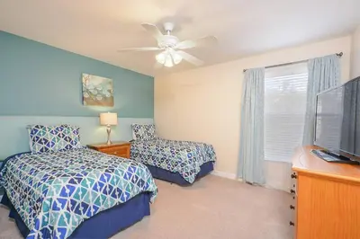 a bedroom with two beds and a ceiling fan at Spacious 6BR Villa Sleeps 14 in Kissimmee