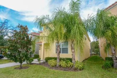 a house with two palm trees in front of it at Spacious 6BR Villa Sleeps 14 in Kissimmee