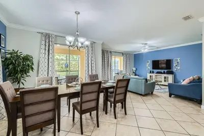 a dining room and living room with a table and chairs at Spacious 6BR Villa w Pool, Game Room & View in Kissimmee