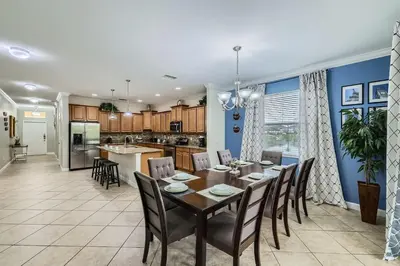 a dining room and kitchen with a table and chairs at Spacious 6BR Villa w Pool, Game Room & View in Kissimmee