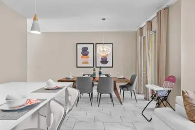 a dining room and living room with a table and chairs at Relaxing Getaway Near Disney with Pool & Themed Rooms in Kissimmee