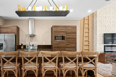 a kitchen with a table with chairs and a refrigerator at 7545 Magic Village - Charmoso e especial, a 6 minutos da Disney in Orlando