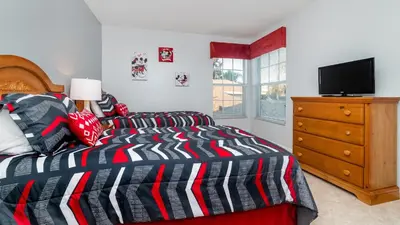 a bedroom with a bed and a dresser with a television at Windsor Palms Resort Vacation Home 5BR in Kissimmee