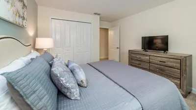 a bedroom with a bed with a television on a dresser at JLT3076 Storey Lake Resort Vacation Townhome in Kissimmee