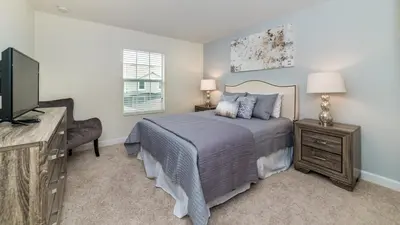 a bedroom with a bed and a flat screen tv at JLT3076 Storey Lake Resort Vacation Townhome in Kissimmee