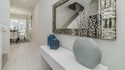 a living room with a table with vases and a mirror at JLT3076 Storey Lake Resort Vacation Townhome in Kissimmee
