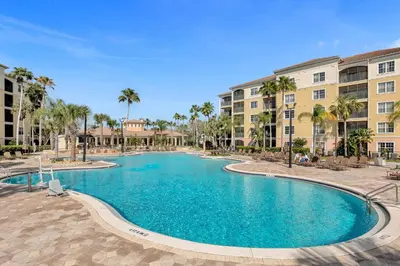 a swimming pool in a resort with palm trees and buildings at 3 Bedroom Family Friendly Condo at WorldQuest near Disney 2714 in Orlando
