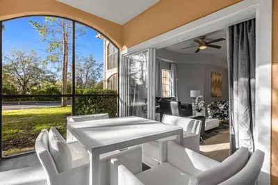 a patio with a white table and white chairs at 3 Bedroom Family Friendly Condo at WorldQuest near Disney 2729 in Orlando