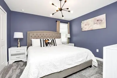 a bedroom with blue walls and a bed with a white bedspread at Serenity Lakeview Retreat Stunning Water Views, No Rear Neighbors, Private Pool, Game Room Star Wars Cinema in Kissimmee