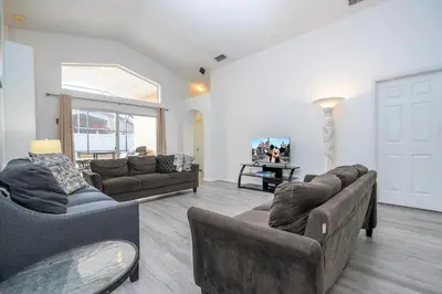 a living room with two couches and a table at Near Disney with Pool and BBQ 4BD Single House in Kissimmee