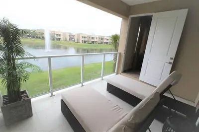 a balcony with a couch and a view of the water at 3212 Magic Village - 8 hóspedes, à beira do lago, 8 minutos da Disney in Orlando