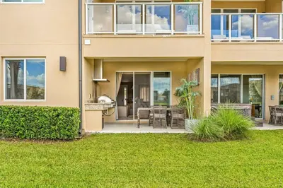 a house with a patio and lawn in front of it at 3212 Magic Village - 8 hóspedes, à beira do lago, 8 minutos da Disney in Orlando