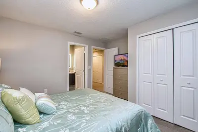 a bedroom with a bed and a closet at Beautiful 4BD home Themed Pool and Grill 4417 in Kissimmee