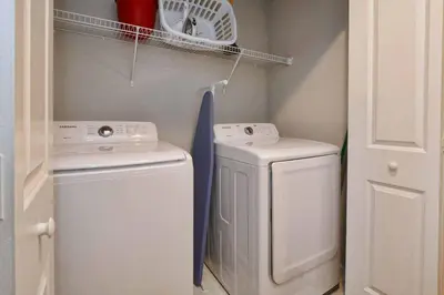 a small laundry room with a washer and dryer at Beautiful 4BD home Themed Pool and Grill 4417 in Kissimmee