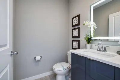 a bathroom with a toilet and a sink and a mirror at Beautiful 4BD home Themed Pool and Grill 4417 in Kissimmee