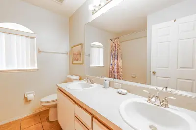a bathroom with a sink and a toilet and a mirror at MVP 1511ABIB LONG TERM in Kissimmee