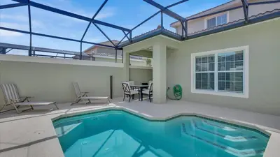 a house with a swimming pool and a table and chairs at CAT8967 in Kissimmee