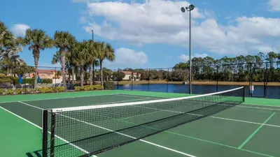 a tennis net on a tennis court with palm trees at CAP8949 in Kissimmee