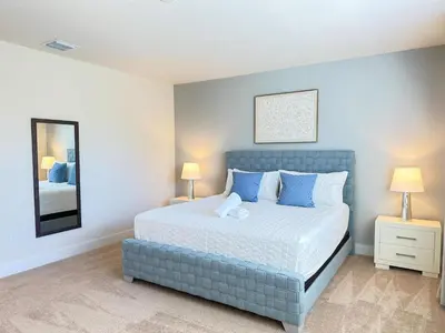 a bedroom with a bed with blue pillows and a mirror at TR1433SL - Island House Orlando in Orlando