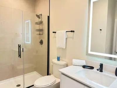 a bathroom with a shower and a toilet and a sink at TR1386PNW - 9 guests - pool home close to Disney in Clermont
