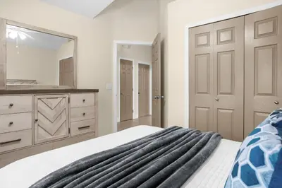 a bedroom with a bed and a large mirror at Spacious Disney Retreat with pool & parking in Kissimmee