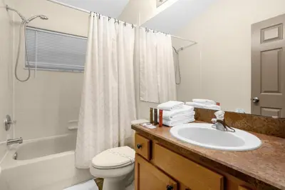 a bathroom with a sink and a toilet and a shower at Spacious Disney Retreat with pool & parking in Kissimmee