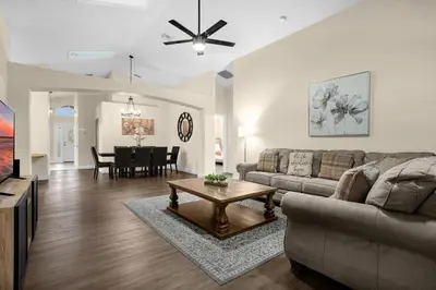 a living room with a couch and a table at Spacious Disney Retreat with pool & parking in Kissimmee