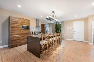 a kitchen with a bar with chairs and a counter at 7458 Magic Village - 8 hóspedes, jacuzzi, 8 minutos da Disney in Orlando