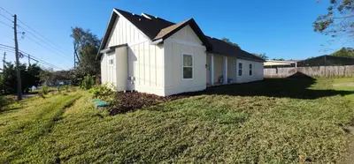 a small white house on the side of a yard at Orlando Home Vacation near Universal Studios - 3 BR in Orlando