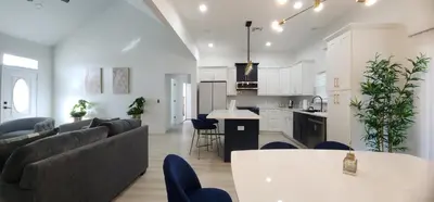 a living room and kitchen with a couch and a table at Orlando Home Vacation near Universal Studios - 3 BR in Orlando