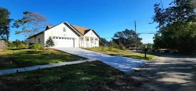 a white house with a driveway at Orlando Home Vacation near Universal Studios - 3 BR in Orlando