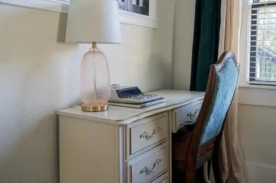 a lamp on top of a desk with a chair at Historic Orlando Casita Love Apt A with backyard in Orlando