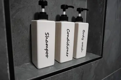 three white bottles on a shelf in a bathroom at Historic Orlando Casita Love Apt A with backyard in Orlando
