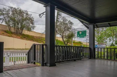 a porch with black pillars and a street sign at Historic Orlando Casita Love Apt A with backyard in Orlando