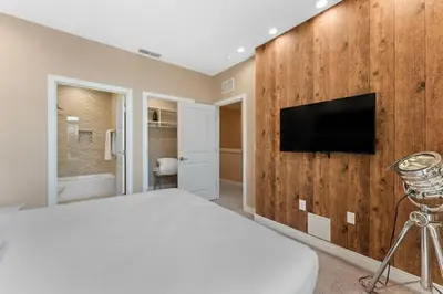 a bedroom with a bed and a tv on a wall at Casa 3 Suítes c/ Jacuzzi e Churrasq. — Disney 6min in Orlando
