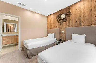 a bedroom with two beds and a clock on the wall at Casa 3 Suítes c/ Jacuzzi e Churrasq. — Disney 6min in Orlando