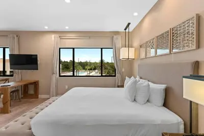 a bedroom with a large white bed and a window at Casa 3 Suítes c/ Jacuzzi e Churrasq. — Disney 6min in Orlando