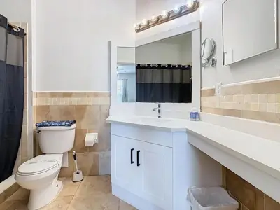 a bathroom with a toilet and a sink and a mirror at Windsor Hills Lovely 3BR Condo Slides Pool Disney in Orlando