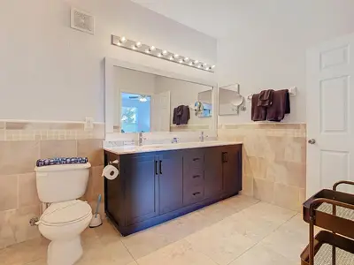 a bathroom with a toilet and a sink and a mirror at Windsor Hills Lovely 3BR Condo Slides Pool Disney in Orlando