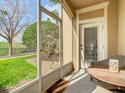 a porch with a wooden table and a large window at Windsor Hills Lovely 3BR Condo Slides Pool Disney in Orlando